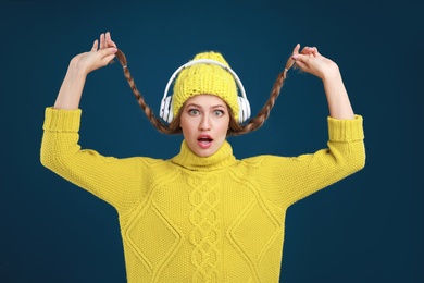 Photo of Young woman listening to music with headphones on dark blue background