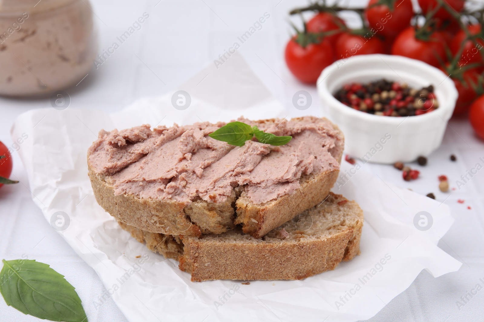 Photo of Delicious liverwurst sandwich with basil on white table