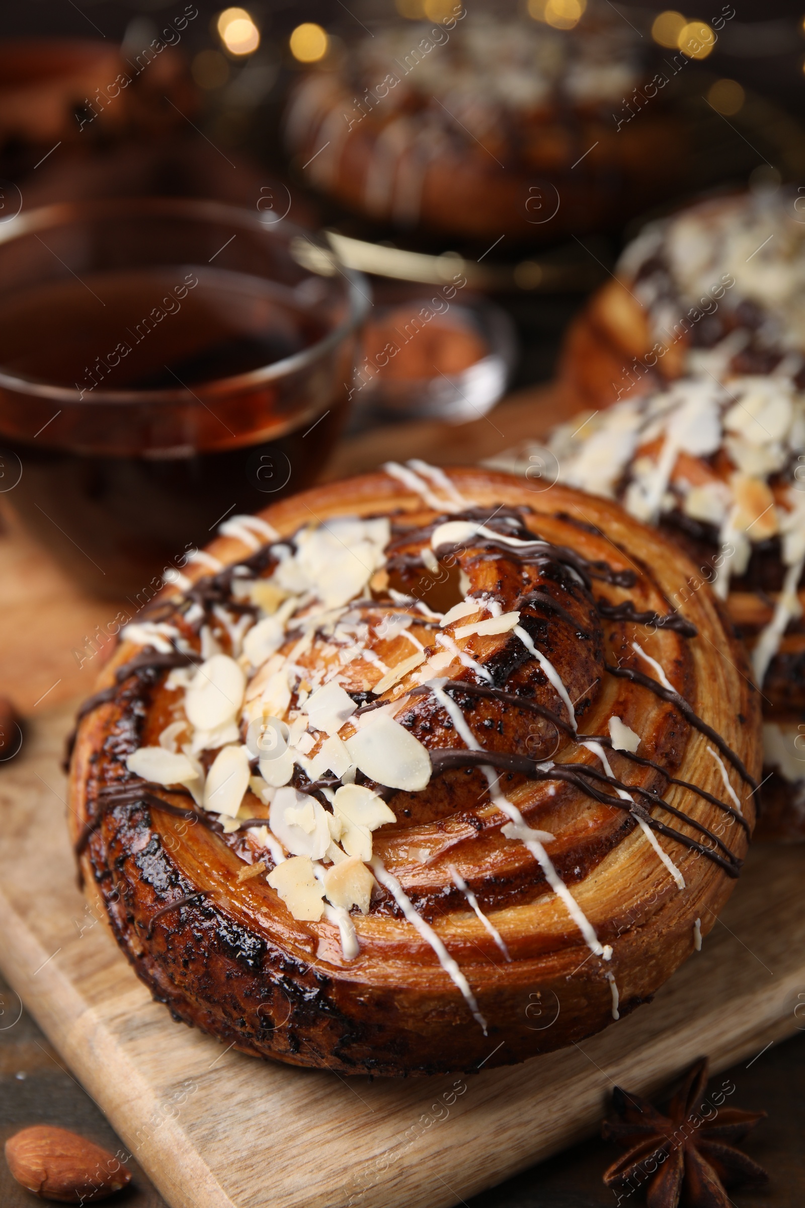 Photo of Delicious roll with toppings and nuts on table, closeup. Sweet bun