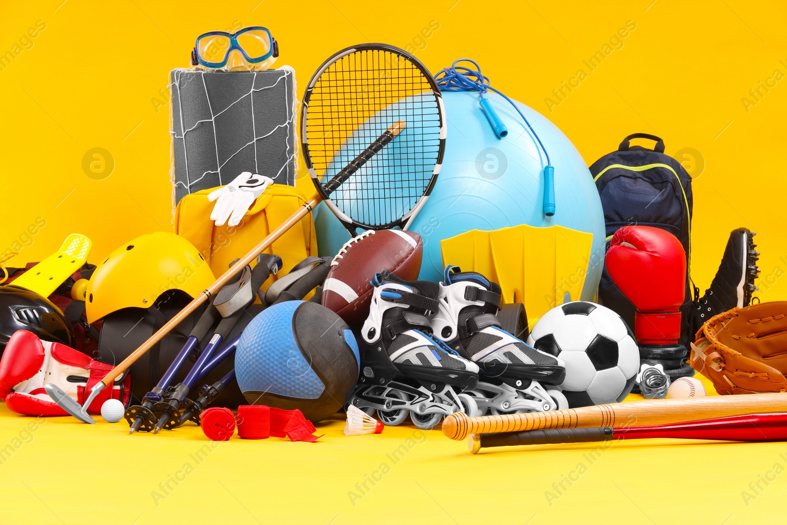 Photo of Many different sports equipment on yellow background