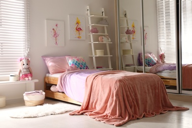 Bed with beautiful linens in children's room. Modern interior design