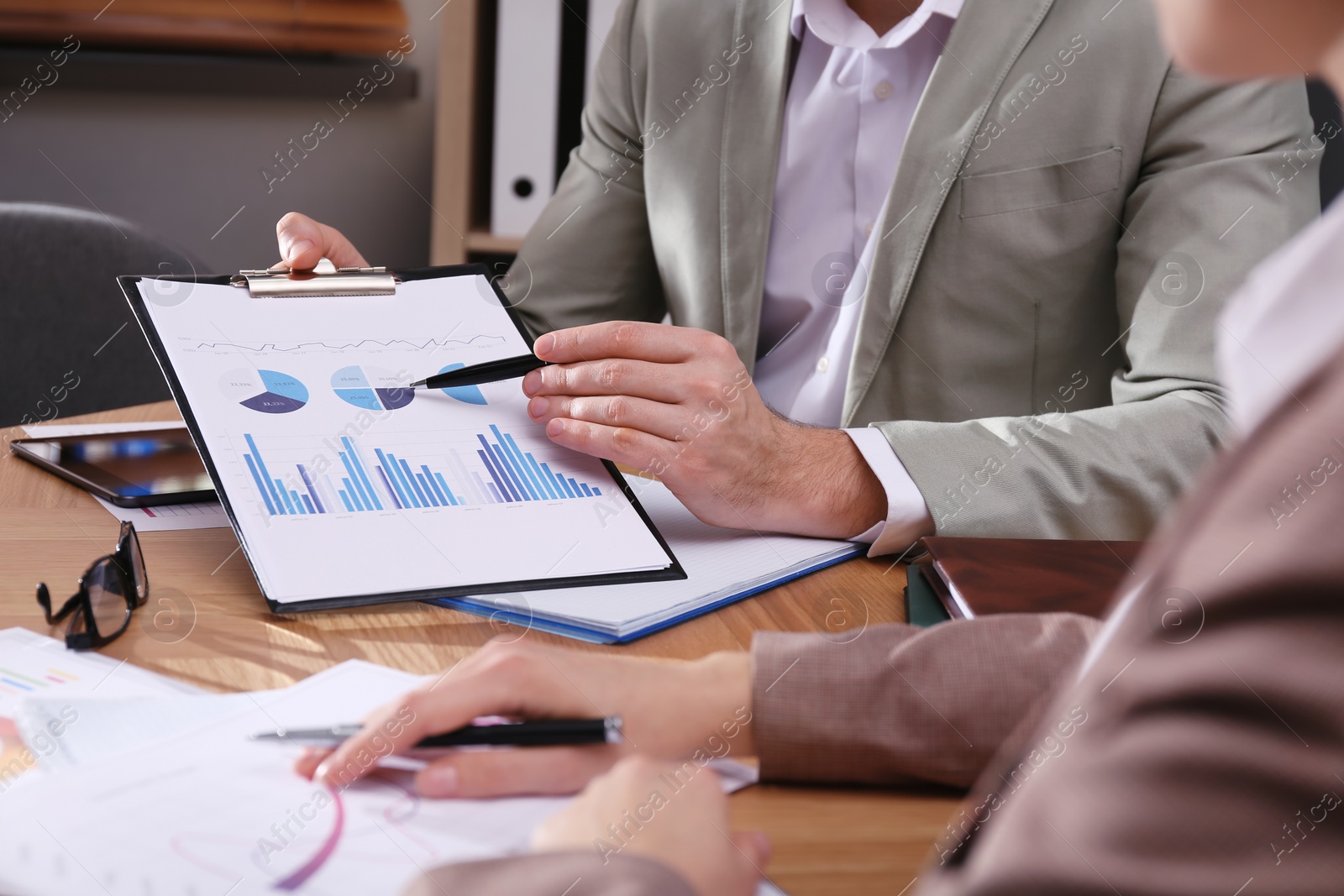 Photo of Business people working with charts and graphs at table in office, closeup. Investment analysis