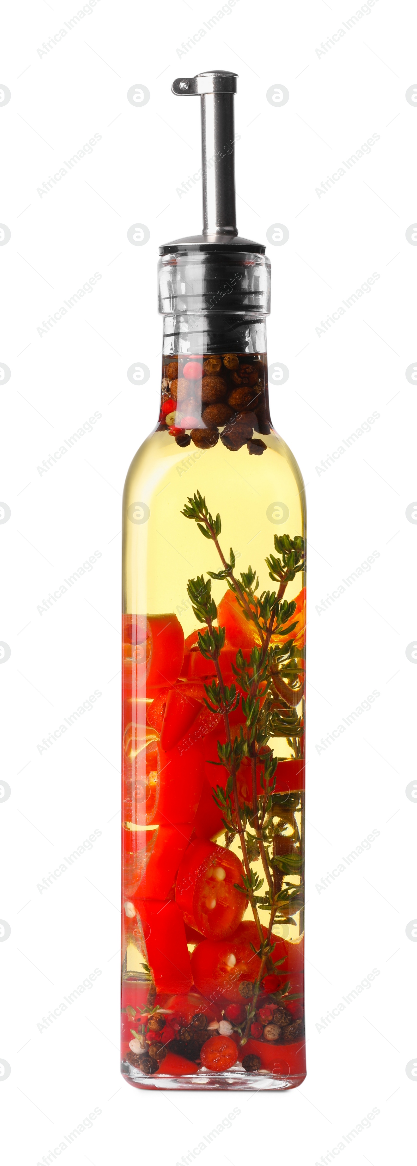 Photo of Glass bottle of cooking oil with spices and herbs isolated on white