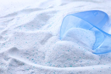 Measuring cup with laundry powder, closeup view. Space for text