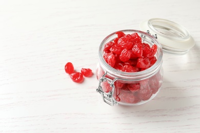 Jar with tasty cherries on wooden background, space for text. Dried fruits as healthy food