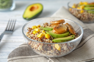 Photo of Healthy quinoa salad with vegetables in bowl on table