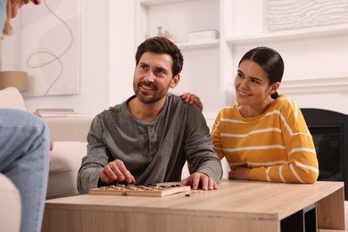 Family talking while playing checkers at home