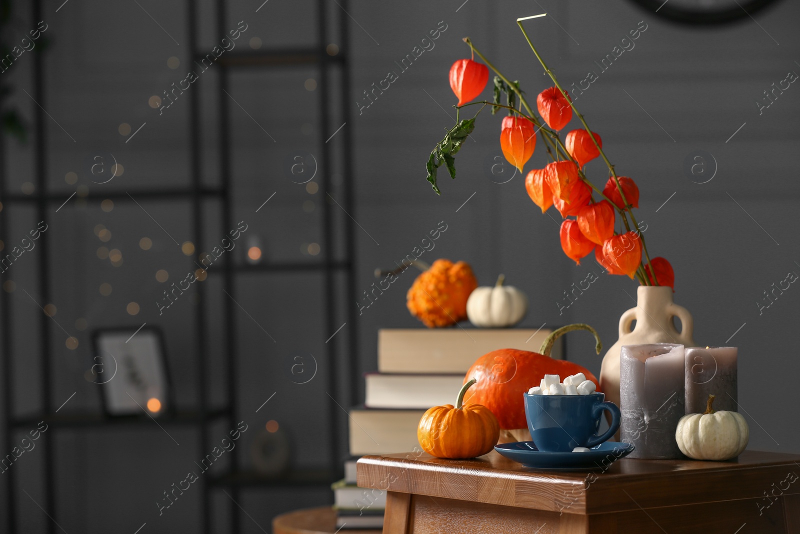 Photo of Beautiful autumn composition with cup of drink and pumpkins on wooden table indoors, space for text