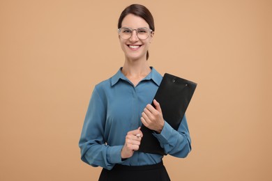 Happy secretary with clipboard on beige background