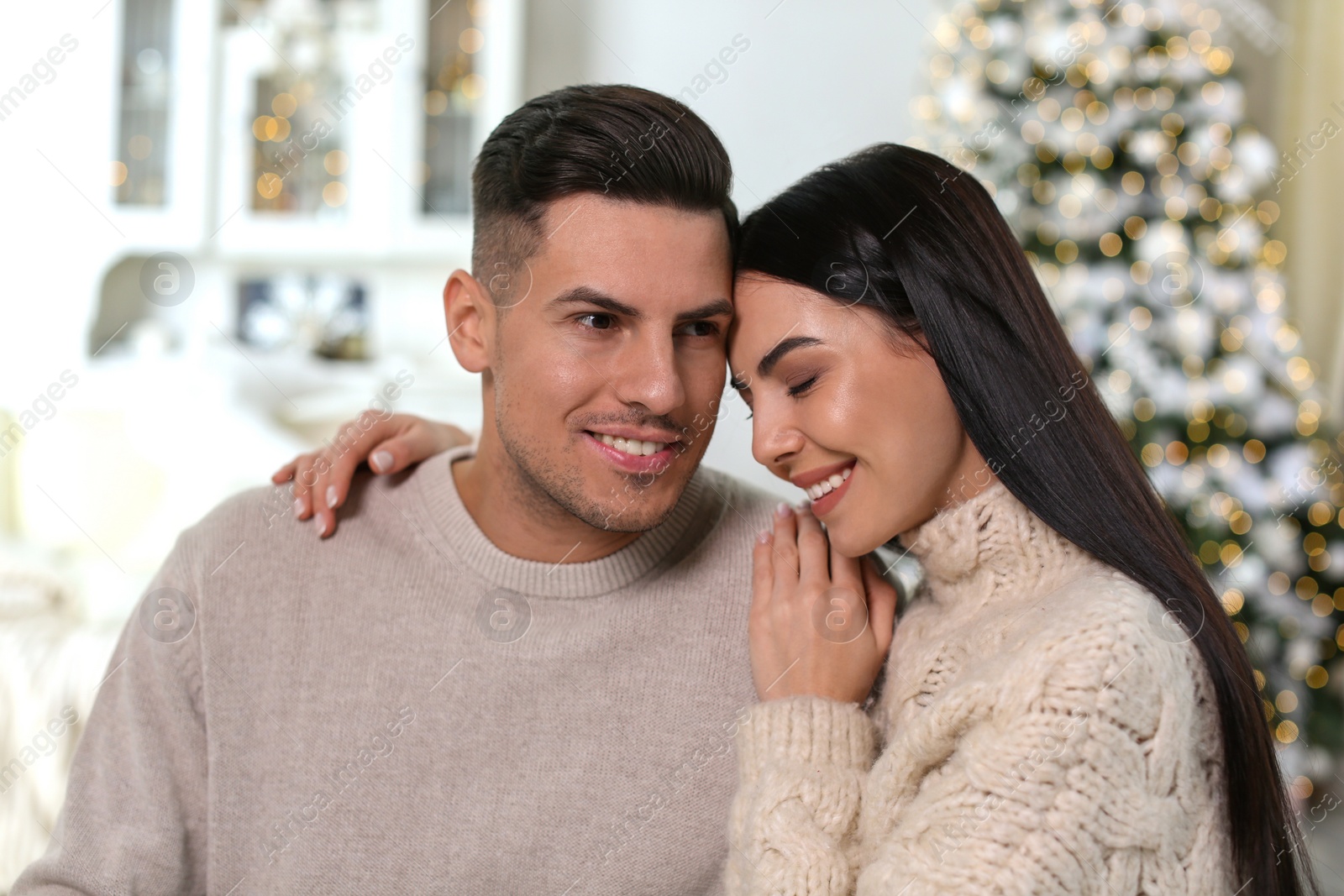 Photo of Happy couple in festively decorated room. Christmas celebration