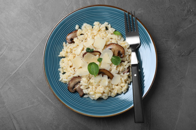 Delicious risotto with cheese and mushrooms on dark grey table, top view