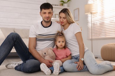 Photo of Family with little daughter spending time together at home