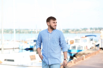 Photo of Young hipster man in jeans on pier