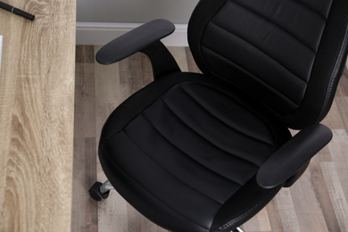Photo of Comfortable office chair near table in room