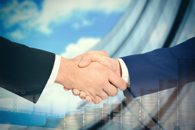 Image of Multiple exposure of partners shaking hands, coins and building. Business values