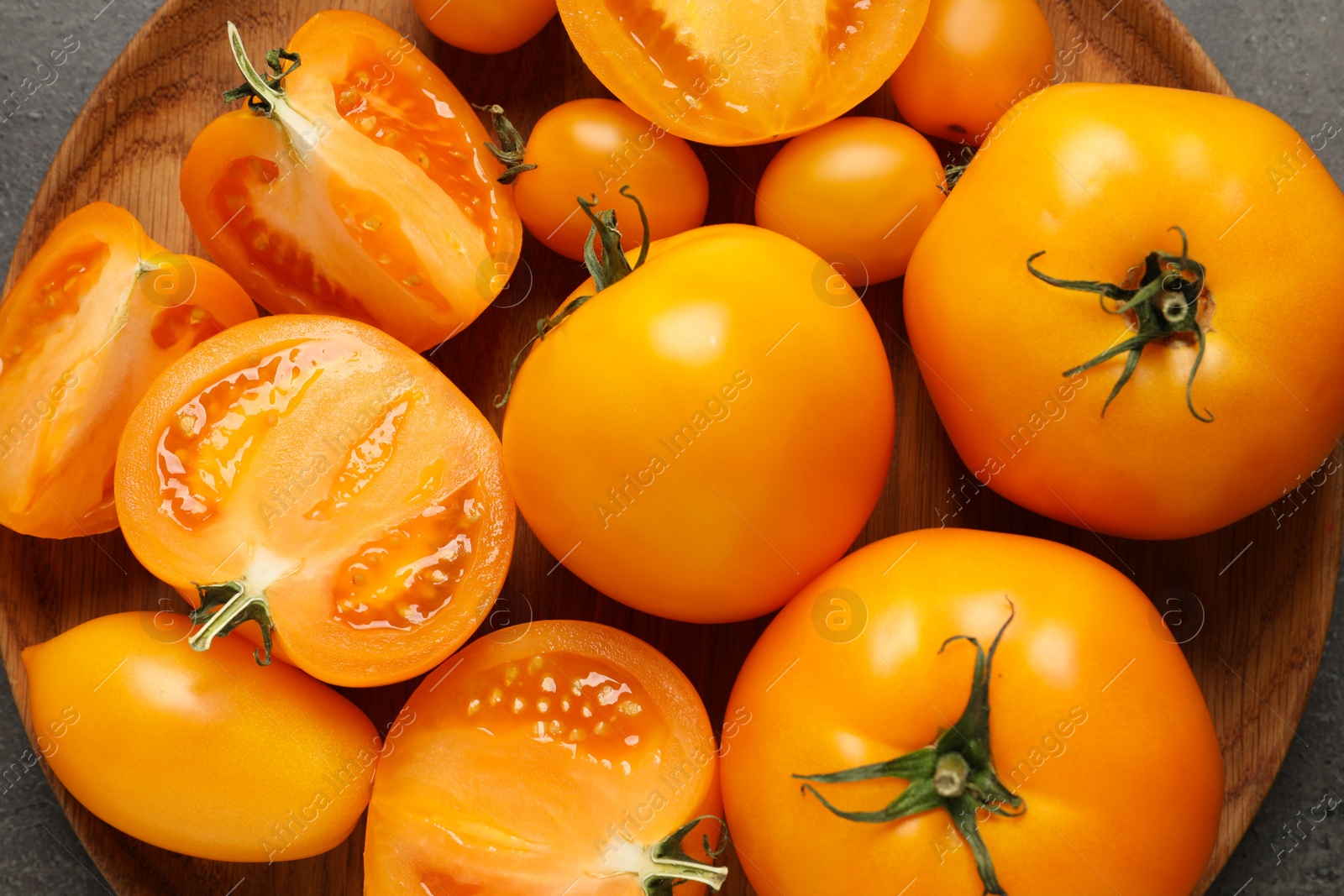 Photo of Fresh ripe yellow tomatoes on grey table, top view