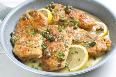 Photo of Delicious chicken piccata with herbs and lemons on table, closeup