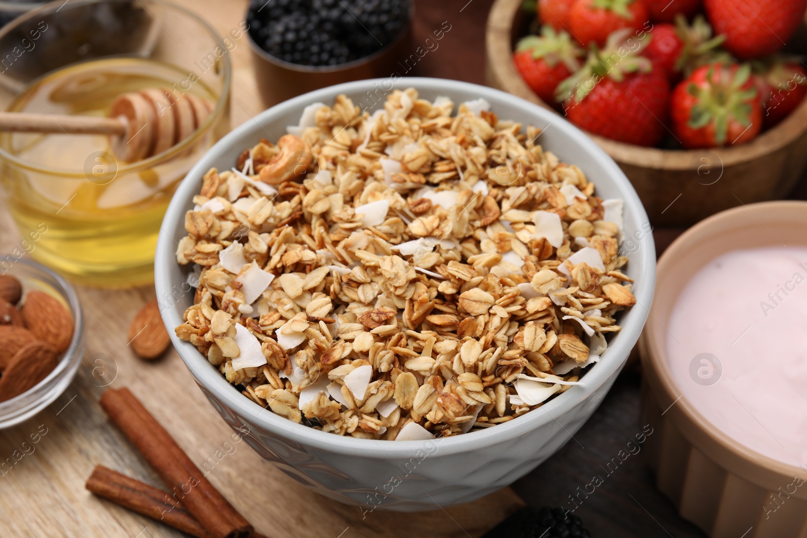 Photo of Tasty granola and ingredients on table, closeup. Healthy breakfast