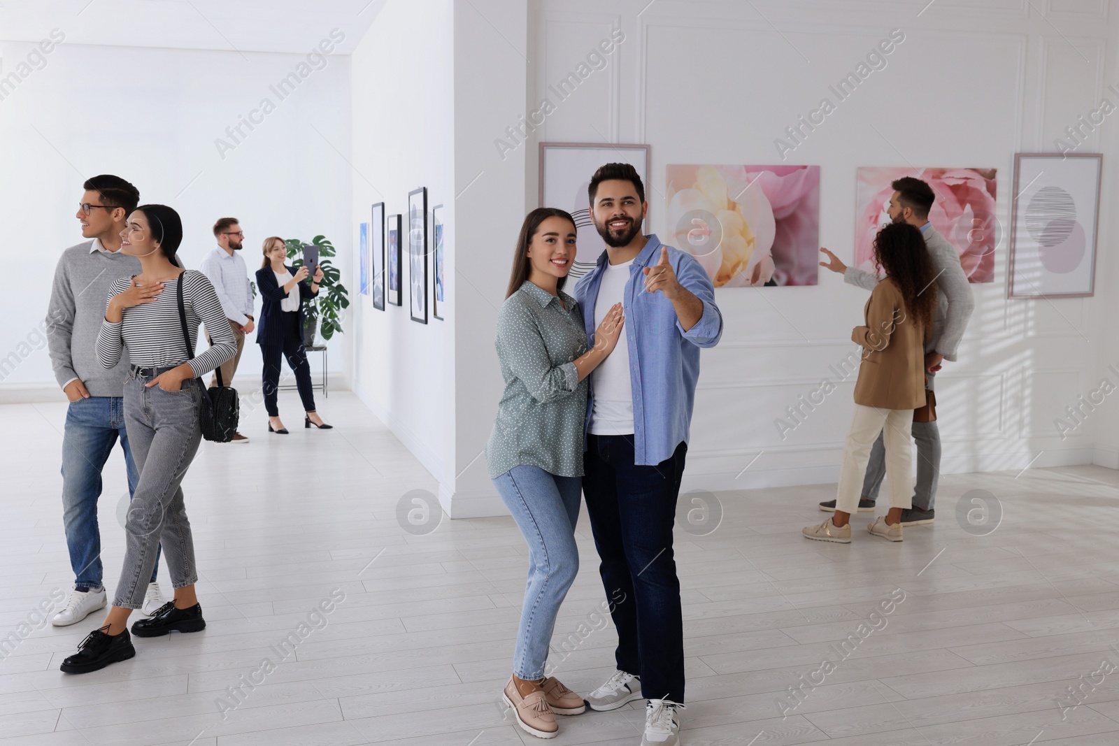 Photo of People viewing exposition in modern art gallery