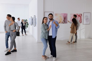 Photo of People viewing exposition in modern art gallery