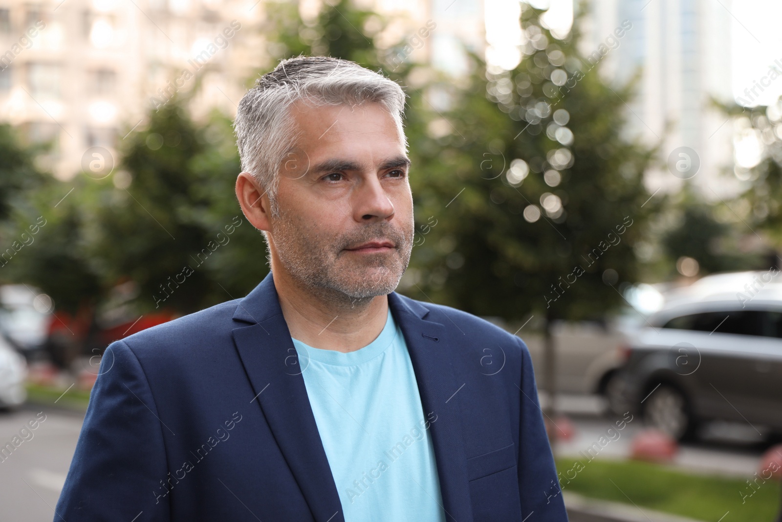 Photo of Portrait of handsome mature man in city center. Space for text