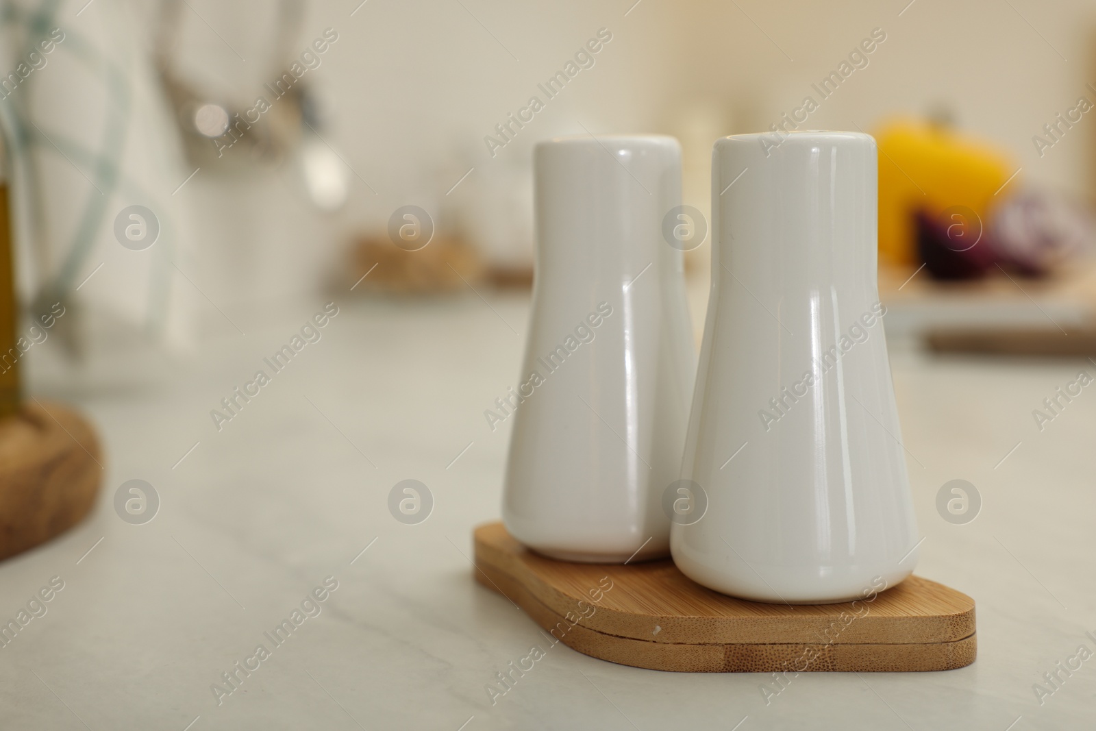 Photo of Ceramic salt and pepper shakers on white countertop in kitchen, space for text