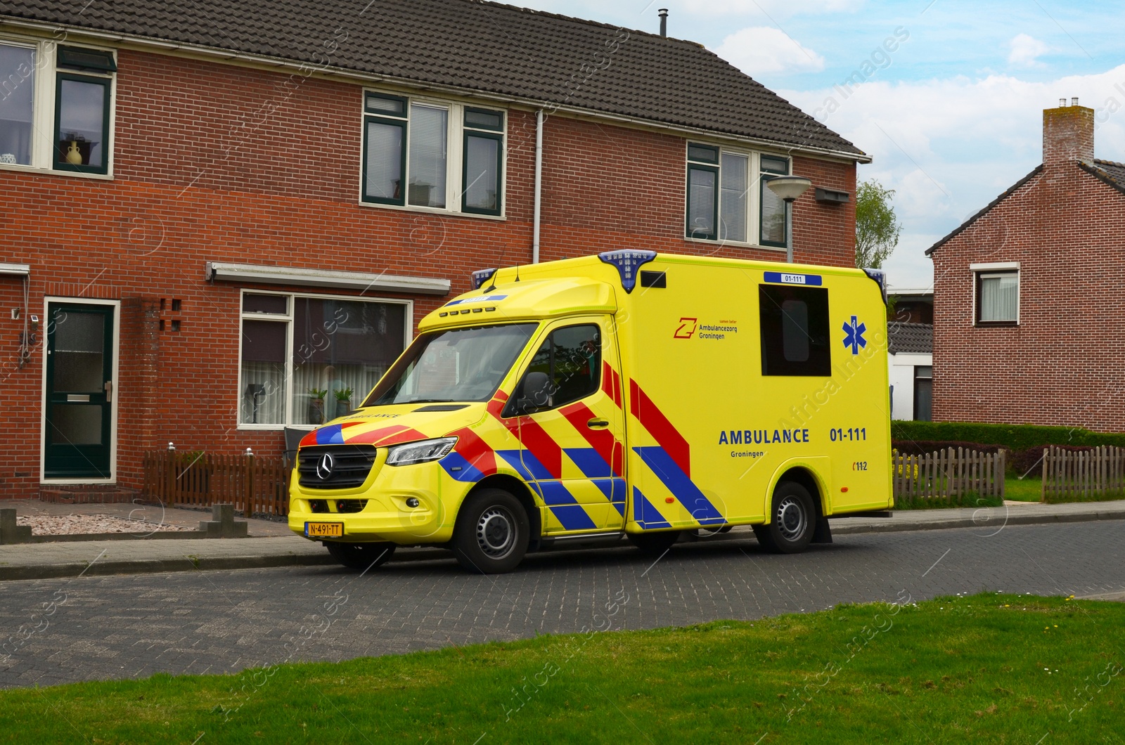 Photo of Veendam, Netherlands - April 30, 2022: Ambulance vehicle near house