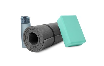 Grey exercise mat, yoga block and bottle of water isolated on white