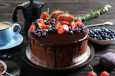 Photo of Fresh delicious homemade chocolate cake with berries on dark table