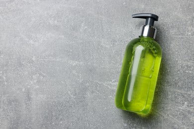 Photo of Dispenser of liquid soap on grey table, top view. Space for text