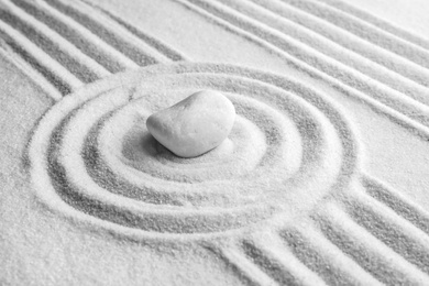 Photo of White stone on sand with pattern. Zen, meditation, harmony