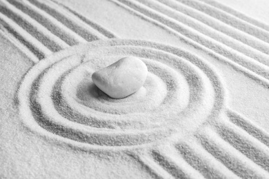 White stone on sand with pattern. Zen, meditation, harmony