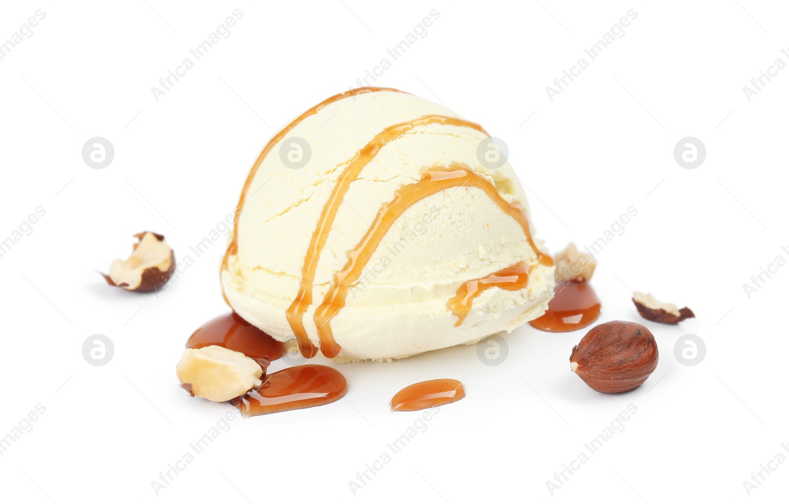 Photo of Ball of delicious vanilla ice cream with hazelnuts and sauce on white background