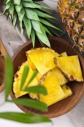 Pieces of tasty ripe pineapple on white wooden table, flat lay