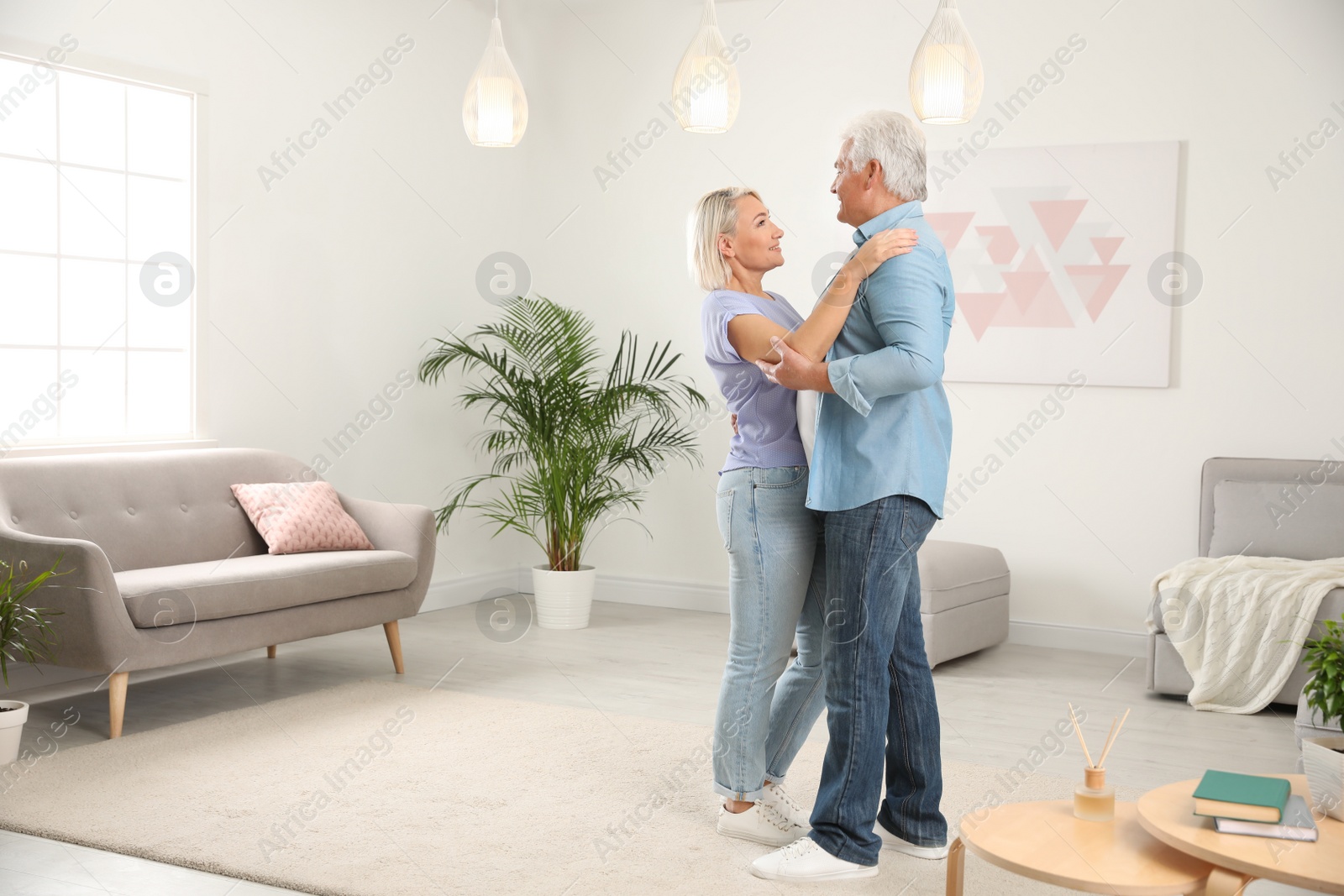 Photo of Happy mature couple dancing together in living room