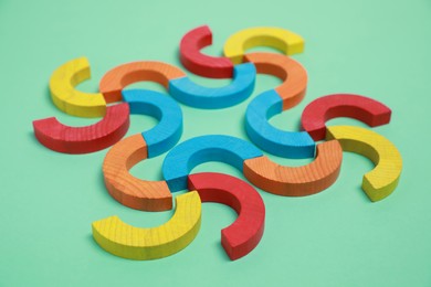 Photo of Colorful wooden pieces of play set on green background. Educational toy for motor skills development