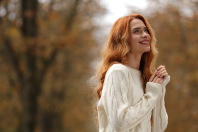 Photo of Autumn vibes. Portrait of smiling woman outdoors. Space for text