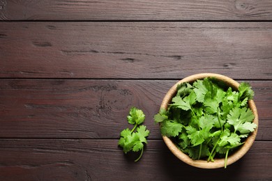 Photo of Fresh aromatic cilantro on wooden table, flat lay. Space for text