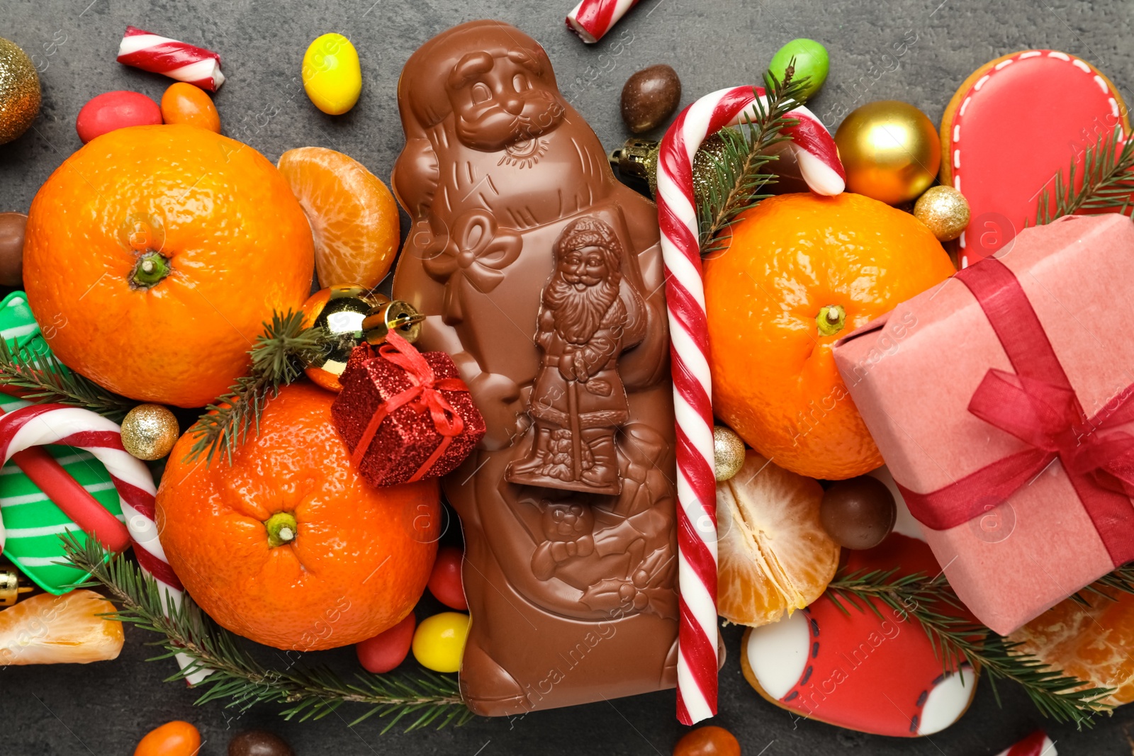 Photo of Flat lay composition with chocolate Santa Claus candies on table, closeup