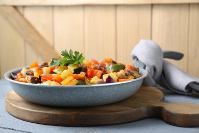 Photo of Delicious ratatouille in frying pan on grey wooden table, space for text