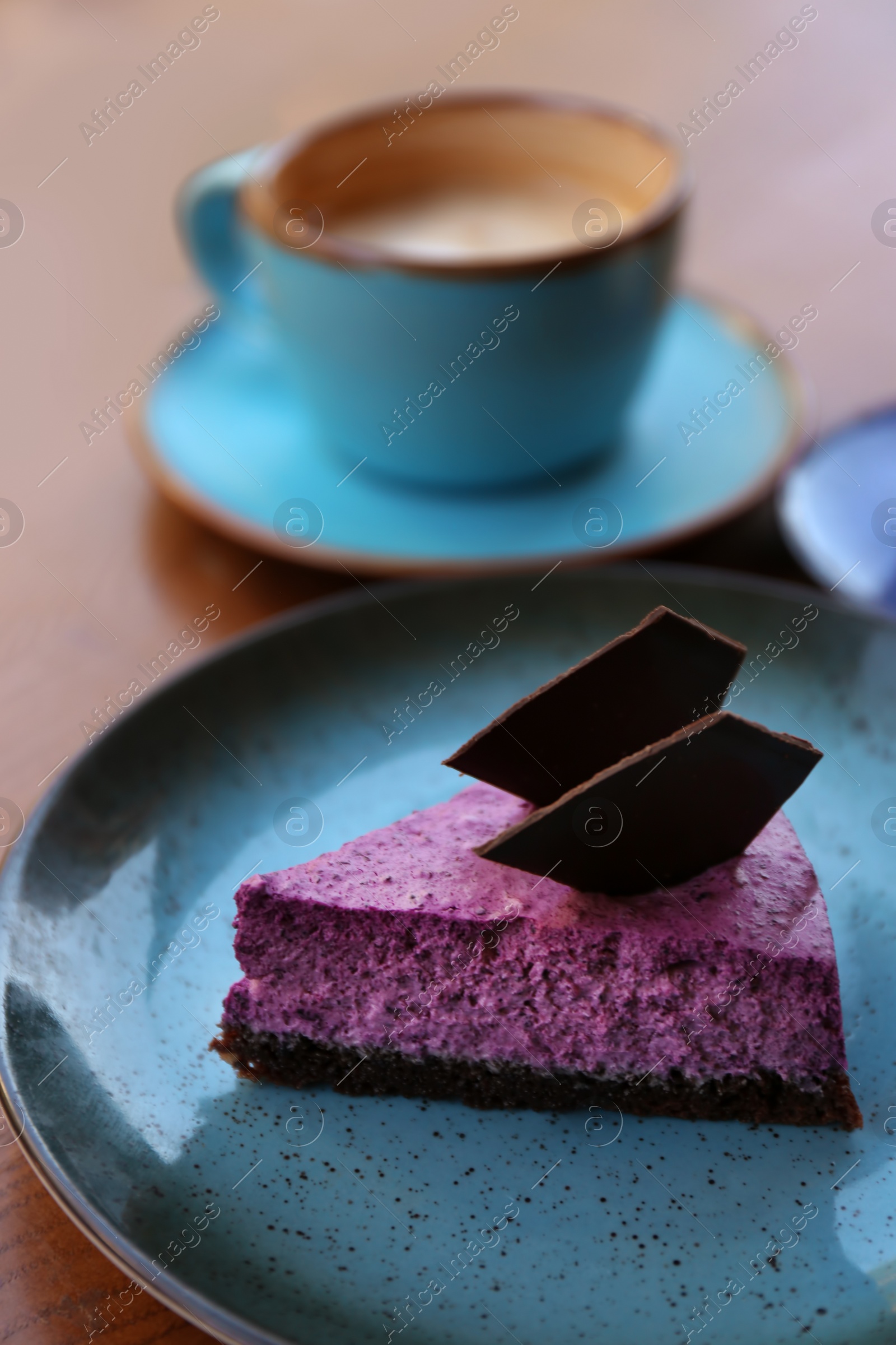 Photo of Plate with slice of berry cheesecake on wooden table