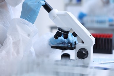 Scientist working with samples and microscope in laboratory, closeup