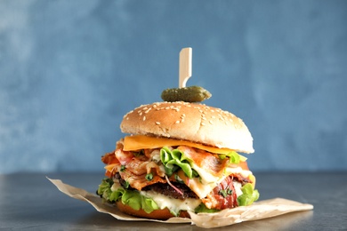 Photo of Tasty burger with bacon served on table