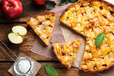 Photo of Traditional apple pie and ingredients on wooden table, flat lay