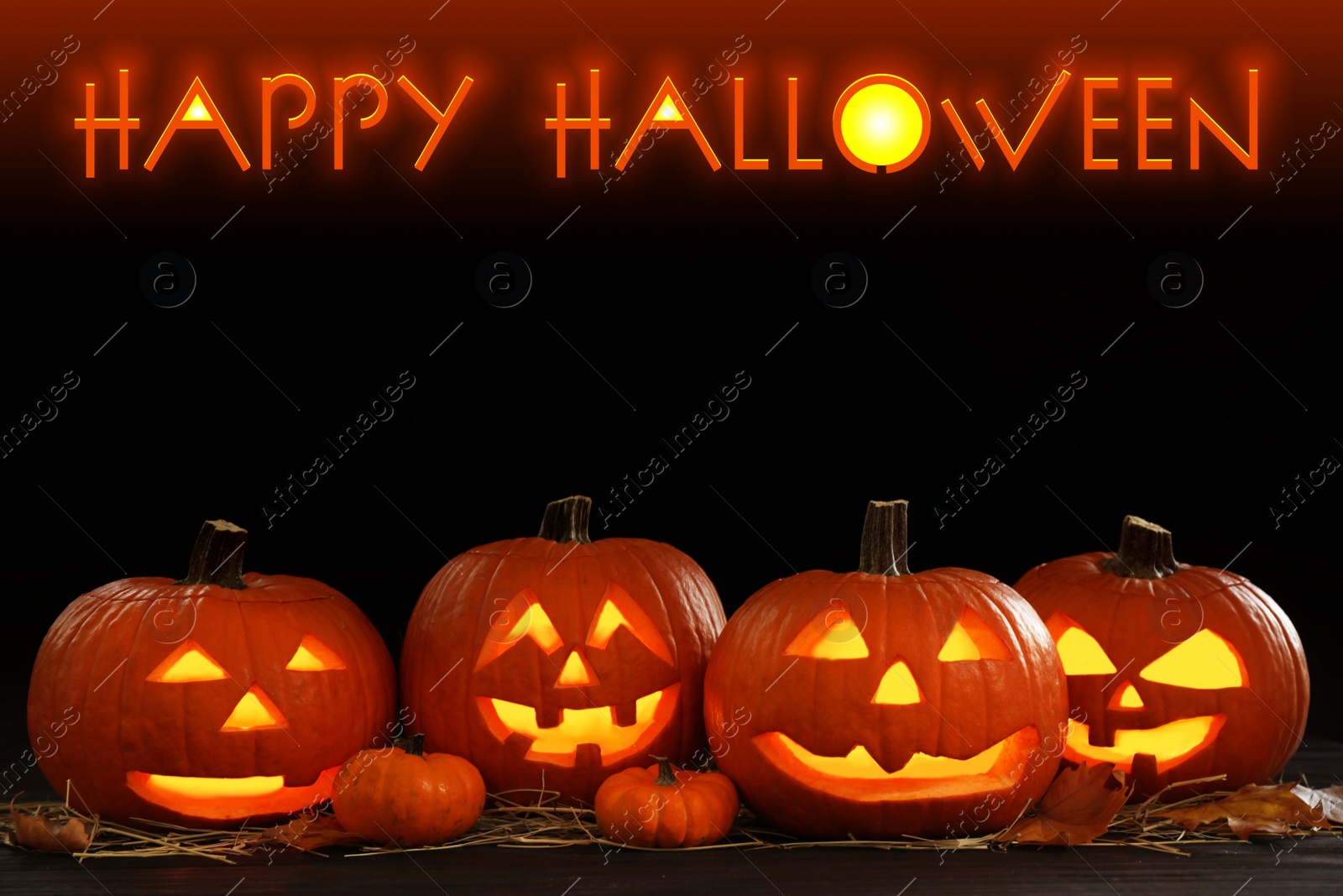 Image of Happy Halloween. Glowing Jack O'lanterns on table in darkness