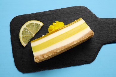 Photo of Delicious cheesecake with lemon on light blue wooden table, top view