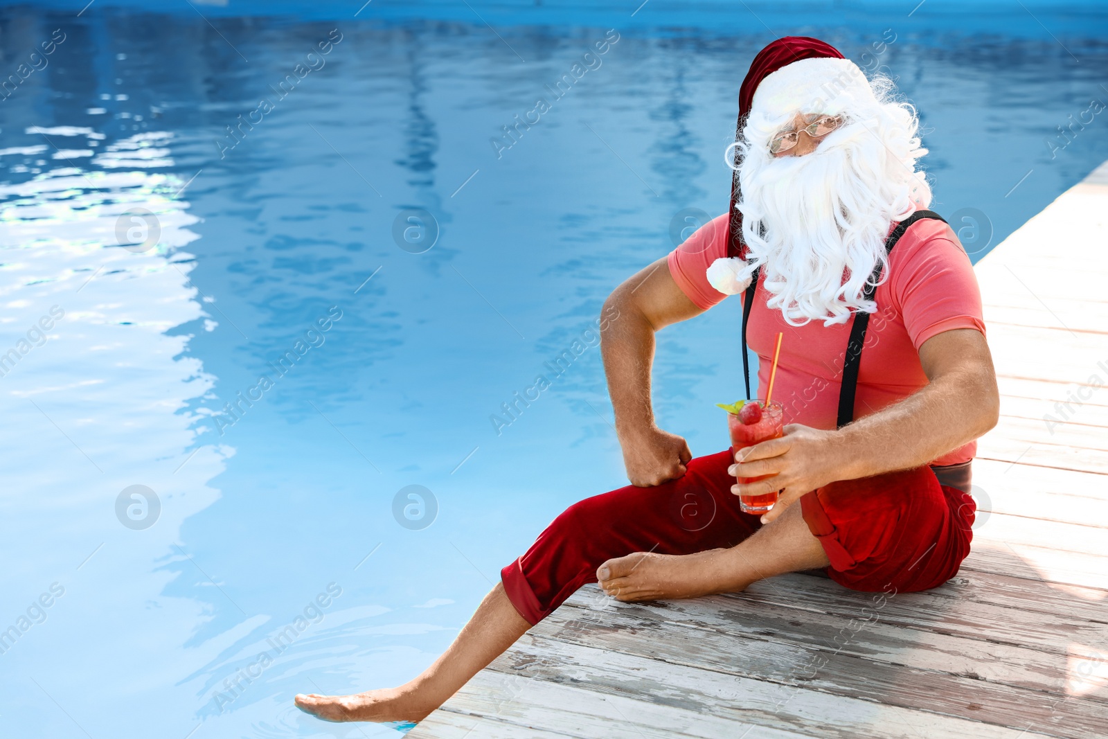 Photo of Authentic Santa Claus with cocktail near pool at resort