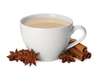 Photo of Cup of tea with milk, anise stars and cinnamon sticks on white background