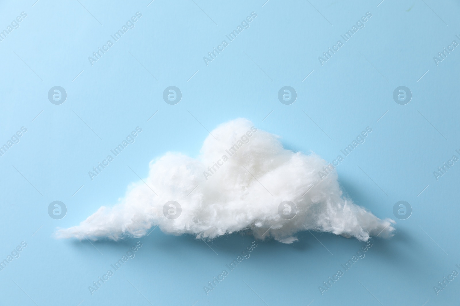 Photo of Cloud made of cotton on light blue background