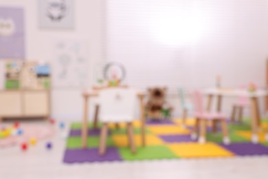 Photo of Stylish kindergarten interior with toys and modern furniture, blurred view